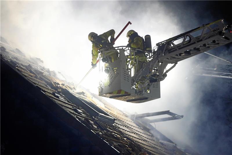 Der komplette Dachstuhl steht in Flammen: Die Feuerwehr deckt das Dach ab, um den Brand bekämpfen zu können. Fotos: Epping