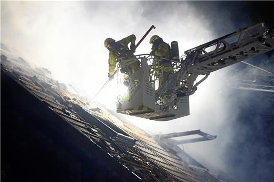 Der komplette Dachstuhl steht in Flammen: Die Feuerwehr deckt das Dach ab, um den Brand bekämpfen zu können. Fotos: Epping