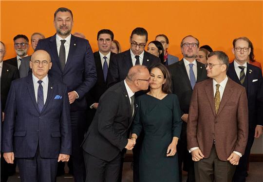 Der kroatische Außenminister Gordan Grlic Radman begrüßt Annalena Baerbock mit einen Kuss beim Gruppenbild im Rahmen der Europakonferenz in Berlin.
