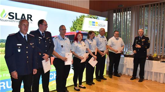 Der künftige Kreisbrandmeister Udo Löprich (l.) und der scheidende Kreisbrandmeister Uwe Fricke (r.) mit einigen der beförderten Feuerwehrleute: Daniel Finster (Löschmeister), Andrea Wellner (Löschmeisterin), Ann-Kathrin Kerwien (Oberlöschmeisterin), Dennis Oberbeck (Hauptlöschmeister), Sebastian Braukhoff (Hauptlöschmeister), Andreas Prost (Hauptlöschmeister), Sven Kasten (Hauptlöschmeister). Patrick Lüs (Hauptlöschmeister) ist nicht auf dem Bild.