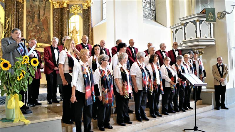 Der langjährige und mittlerweile verstorbene Vorsitzende des Kreis-Chorverbandes Nordharz, Bernd Möller (l.), kündigt 2022 den Auftritt der Okeraner Chöre Frauenchor Frohsinn und MGV Fortuna an. Fotos: Dürich