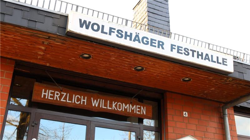 Eingang eines Gebäudes mit dem Schild 'WOLFSHÄGER FESTHALLE' und darunter dem Schild 'HERZLICH WILLKOMMEN'