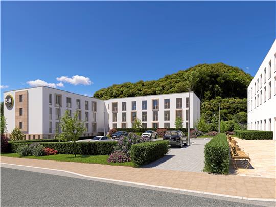 Der neue Hotelkomplex in einer Visualisierung von der Kurhausstraße aus gesehen. Links das „B&B-Hotel“, das im Sommer 2026 eröffnen soll, rechts der zweite Bauabschnitt, im Hintergrund der Burgberg.  Darstellungen: Realique Investment