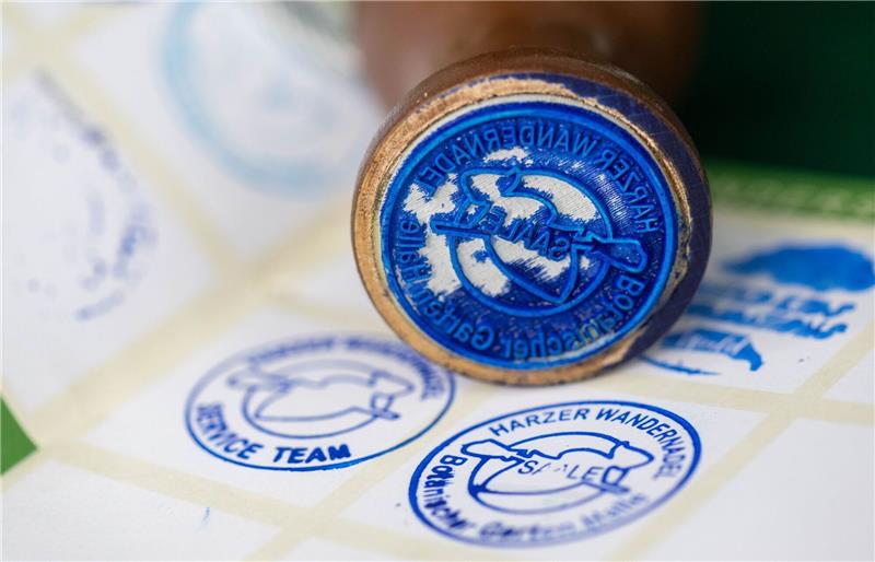 Wandern und Stempel sammeln: Harzer Wandernadel startet Der neue Stempel der Harzer Wandernadel ist vor einem Wanderpass zu sehen.
