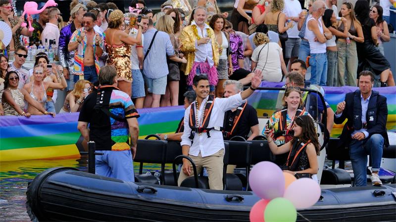 Der niederländische Ministerpräsident Rob Jetten steht auf einem Boot und winkt während der Canal Parade in Amsterdam.