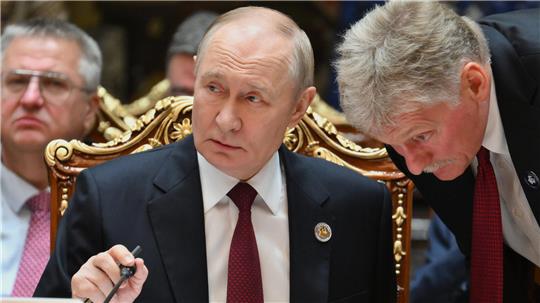 Der russische Präsident Wladimir Putin (l.) spricht mit Kreml-Sprecher Dmitri Peskow während des Gipfels der Gemeinschaft Unabhängiger Staaten im Palast der Nation. 