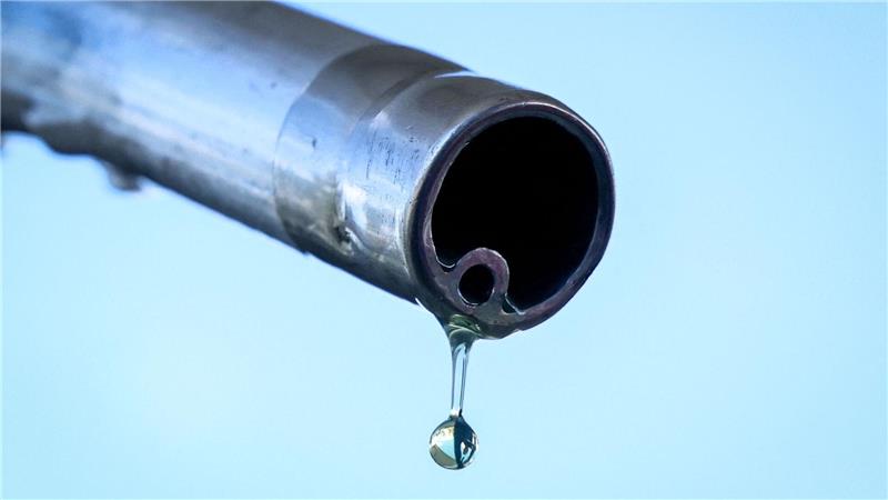 Der soll doch in den Tank! Ein Tropfen Benzin an einer Zapfsäule auf dem Weg nach unten. 