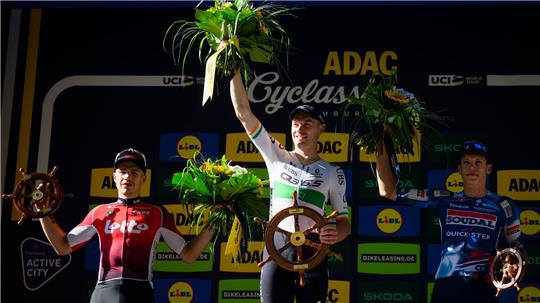 Der zweitplatzierte Belgier Arnaud De Lie (l-r), der Sieger aus Irland Rory Townsend und der drittplatzierte Franzose Paul Magnier bei der Siegerehrung der Cyclassics.