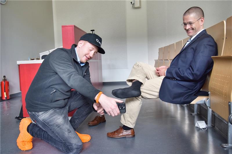 Cornelius Schmitt entwickelt Schuhe aus dem 3D-Drucker „Design ist kein Experiment“, sagt Cornelius Schmitt. Der studierte Wirtschaftsingenieur hat bereits seine eigene Firma in Hamburg und einen Standort in San Francisco. Seine Schuhe befinden sich derzeit in der Beta-Testphase. Schmitt scannt TU-Vize-Präsident Christian Bohns Füße – er bekommt auch ein paar 3D-gedruckte Schuhe. Fotos: Neumann