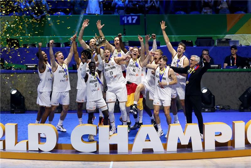 Deutschlands Dennis Schröder (4.vl) hebt den Pokal bei der Siegerehrung hoch und feiert mit dem Team den WM-Titel.