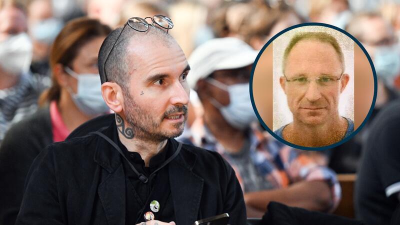 Ein Mann sitzt mit Brille auf dem Kopf in einer Menschenmenge.