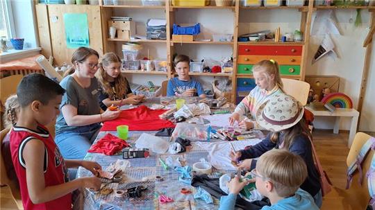 Diakonin Carina Dohmeier und die Ferienpasskinder bei der Upcycling-Aktion.