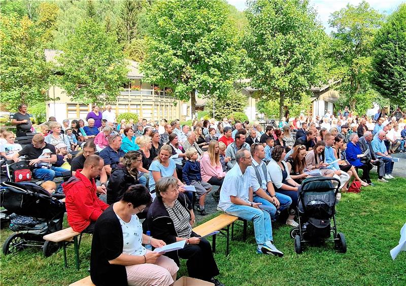 Täuflinge empfangen Segen in der Oker bei Altenau Dicht beisammen sitzen die Besucher des Tauffestes im Kurpark. Foto: Weiss