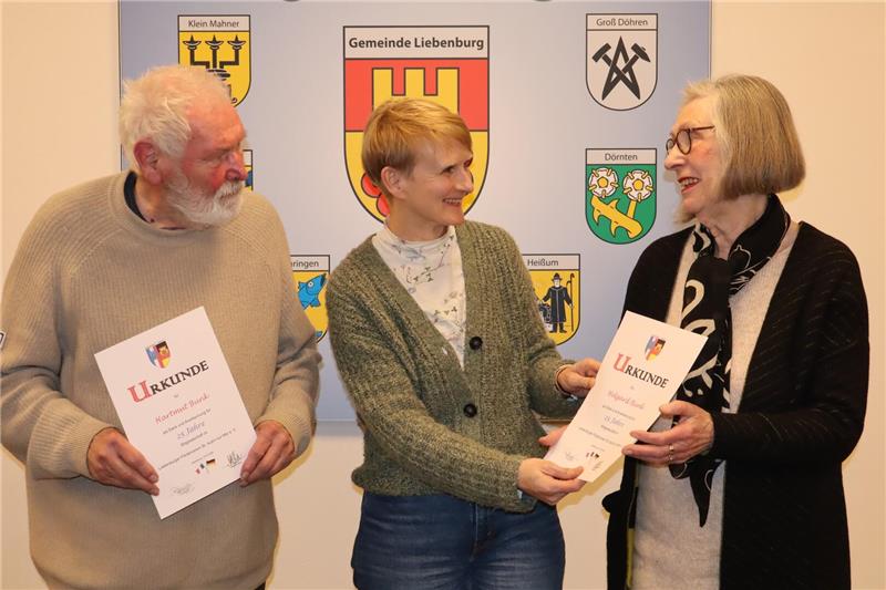 Frau überreicht zwei Urkunden.  