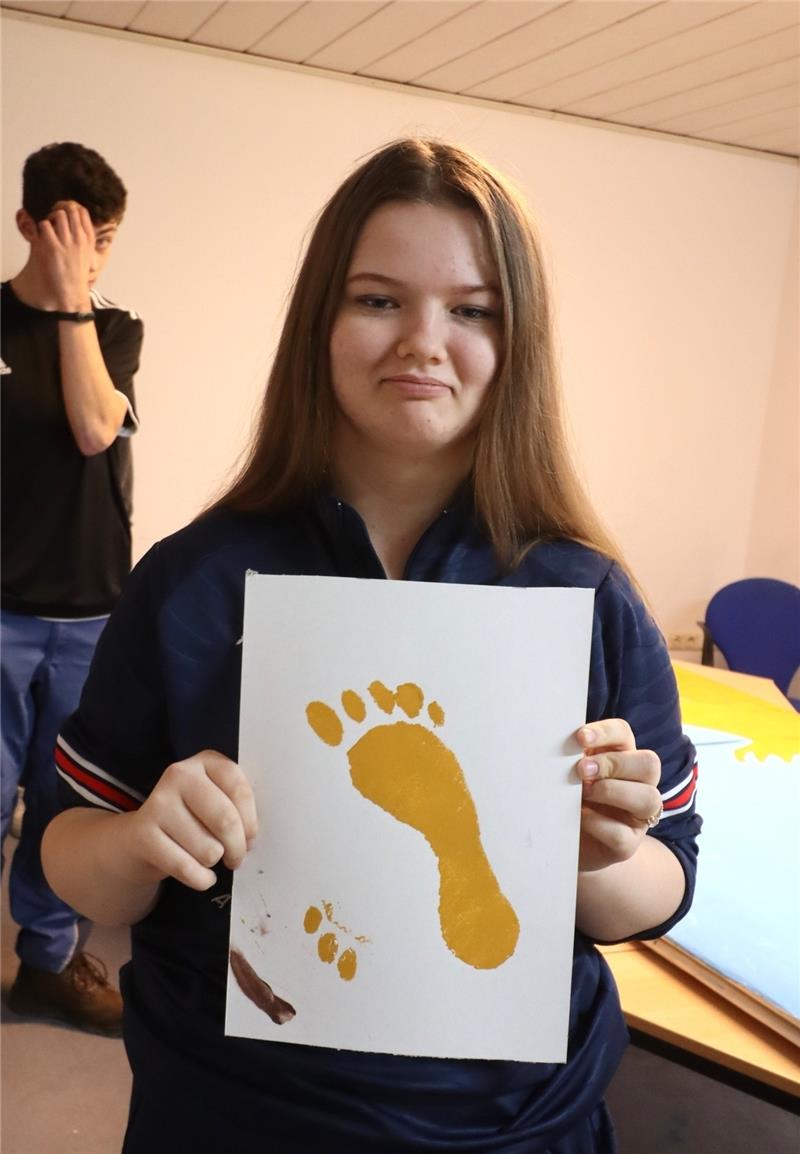 Die 13-jährige Melissa Götze mit einem der Fußabdrücke zur Flüchtlingsroute.
