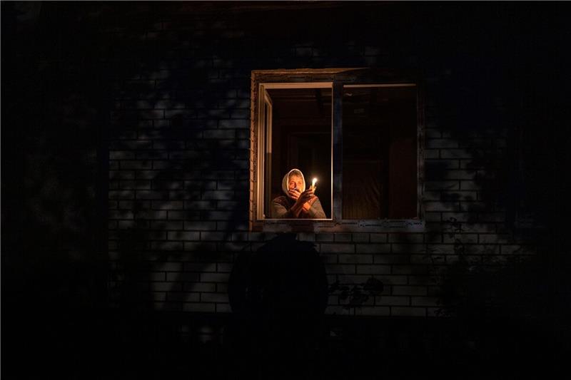Ukraine auf der Suche nach Trafos für Stromnetz Die 70-Jährige Catherine steht während eines Stromausfalls in Borodjanka mit einer Kerze am Fenster.