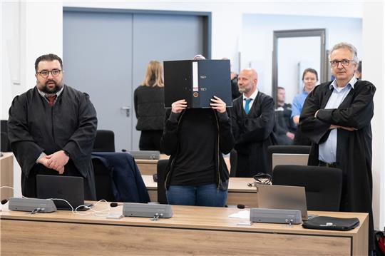 Die Angeklagte (M) steht bei der Fortsetzung des Prozesses im OLG Dresden im Verhandlungssaal.
