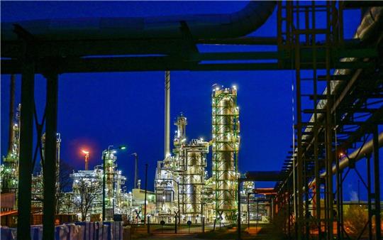 Die Anlagen der Erdölraffinerie auf dem Industriegelände der PCK-Raffinerie GmbH sind abends beleuchtet.