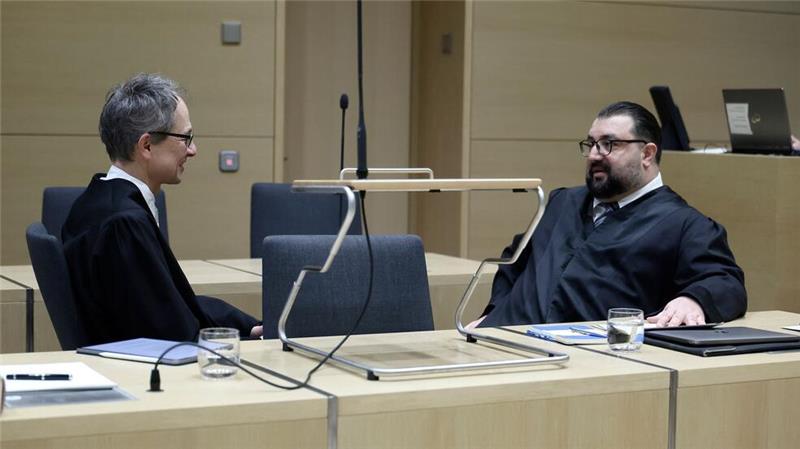 Die Anwälte von E. besprechen sich vor der Verhandlung.