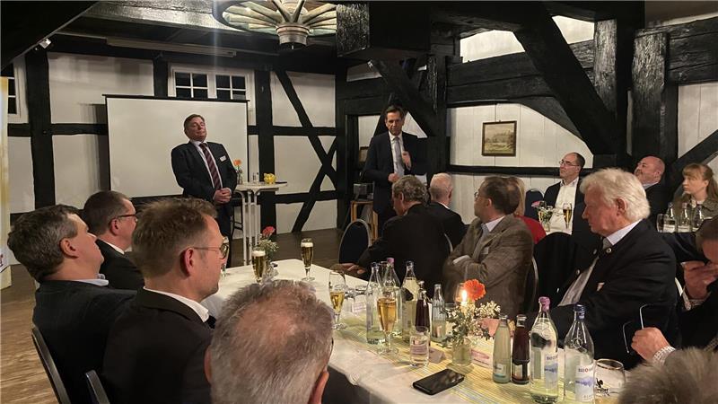 Eine Gruppe Menschen sitzen an einem Tisch. Veranstalter Hans-Heinrich Haase-Fricke und Ministerpräsident Olaf Lies sprechen zu den Anwesenden.