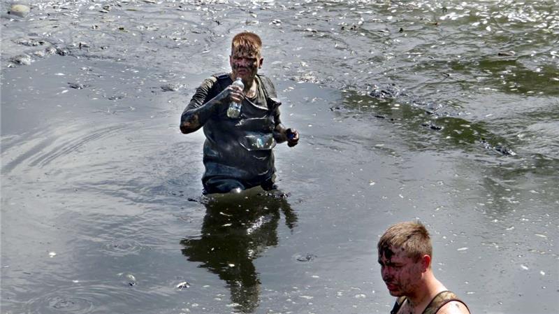 Die Arbeit im Mühlenteich gleicht einer Schlammschlacht. In Wathosen sind die Mitglieder des Angelsportvereins Lutter im Weidenteich unterwegs, um ihn abzufischen. Hätten die Angler nicht eingegriffen, wären die Tiere verendet.  Fotos: Privat, Biener, Gereke