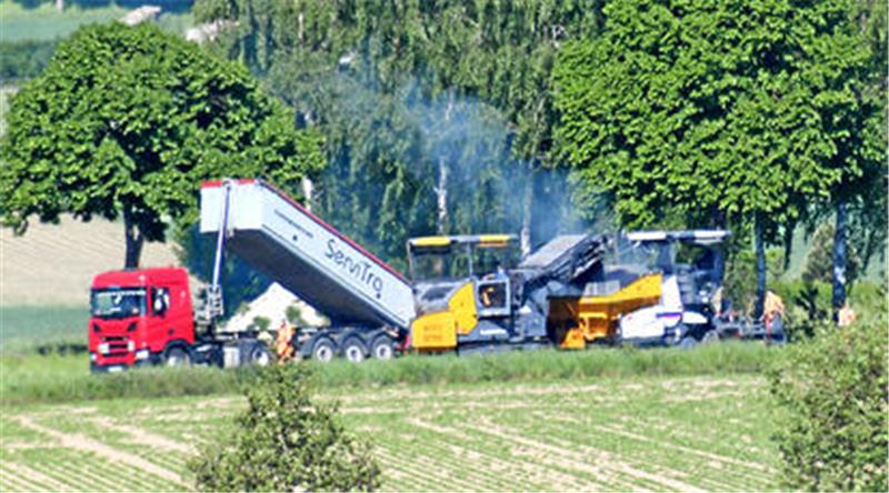Straßenbau: Bei Nauen steigt der Rauch der Asphaltkolonne auf Die Asphaltkolonne arbeitet sich von Nauen kommend auf der Kreisstraße in Richtung Bundesstraße 248 vor.
