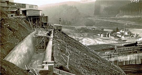 Die Aufnahme vom 11. November 1929 zeigt den Überlauf der Haupttalsperre. Im Tal sind der eingeschalte Betonkern und dahinter die Fabrik Mariental zu sehen. Nach dem Abriss der Fabrikanlagen entsteht an dieser Stelle das „Kurhotel Mariental“, das inzwischen ebenfalls schon Geschichte ist. Foto: Stadt Osterode