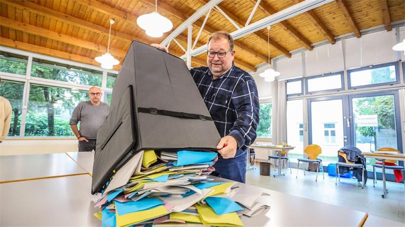 Ein Mann schüttet die Wahlurne aus.