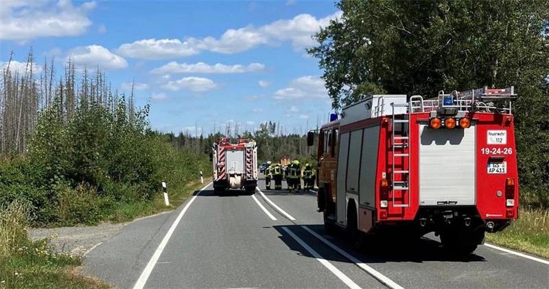 Das Auto zeigt Feuerwehrwagen und mehrere Feuerwehrleute auf einer Straße.