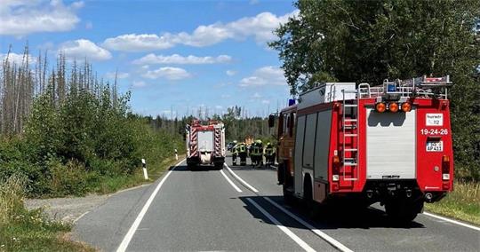 Das Auto zeigt Feuerwehrwagen und mehrere Feuerwehrleute auf einer Straße.