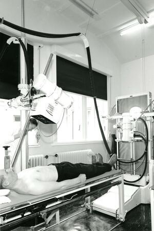 Mann in Behandlungsraum mit technischen Gerätschaften