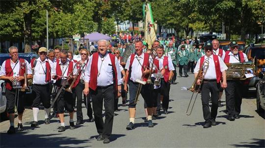Das Foto zeigt maschierende Musiker mit ihren Instrumenten.
