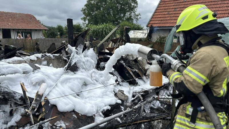 Gartenhaus gerät durch Fahrlässigkeit in Vollbrand Die Brandreste werden mit einem Schaummittel bedeckt