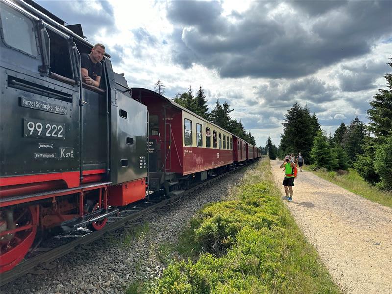 Ein Lokführer schaut aus dem Fenster seines Gefährts und wird dabei im Brockengebiet von einem Wanderer fotografiert.