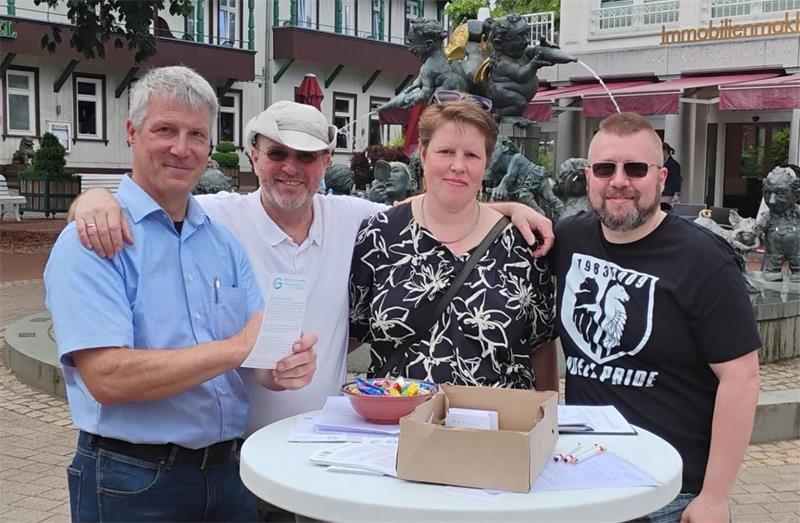 Vier Personen stehen an einem Wahlstand und machen Werbung für ihre Bürgerliste. 