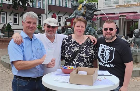 Vier Personen stehen an einem Wahlstand und machen Werbung für ihre Bürgerliste. 