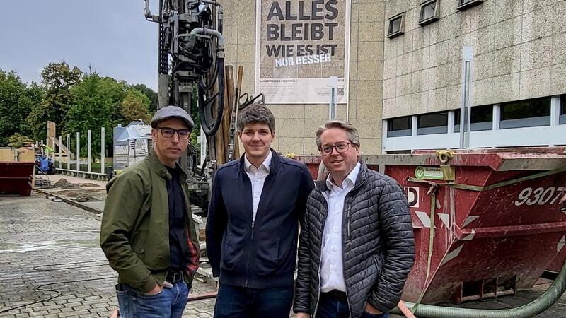 Pfalzquartier: „Gut durchdachtes und einzigartiges Gebäude“ Die Büroleitung von „d/b/d“ (v.l.): Jörn Potthast, Morten Ostermannn und Christian Drescher stehen vor der Baustelle der Stadthalle Braunschweig. Im Hintergrund ist das Bohrgerät zu sehen, das das Erdsondenfeld zur umweltschonenden Beheizung der Stadthalle anlegt.