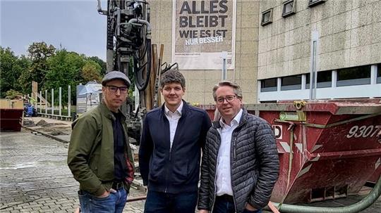 Die Büroleitung von „d/b/d“ (v.l.): Jörn Potthast, Morten Ostermannn und Christian Drescher stehen vor der Baustelle der Stadthalle Braunschweig. Im Hintergrund ist das Bohrgerät zu sehen, das das Erdsondenfeld zur umweltschonenden Beheizung der Stadthalle anlegt.