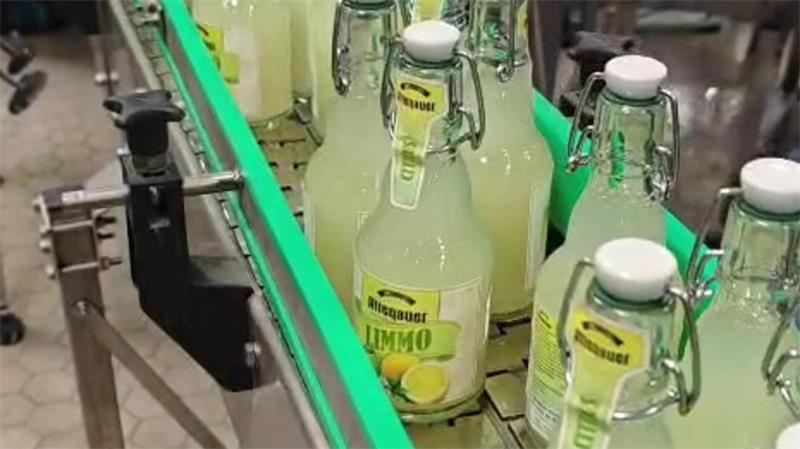 Auf einer Abfüllanlage stehen etliche Flaschen Limonade.