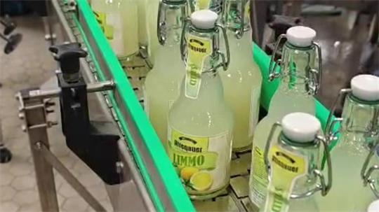 Auf einer Abfüllanlage stehen etliche Flaschen Limonade.