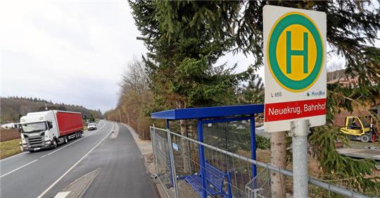 Straße mit wartendem Verkehr, Haltestellenschild „Neukrug, Bahnhof“