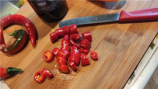 Die Chilis werden kleingeschnitten.