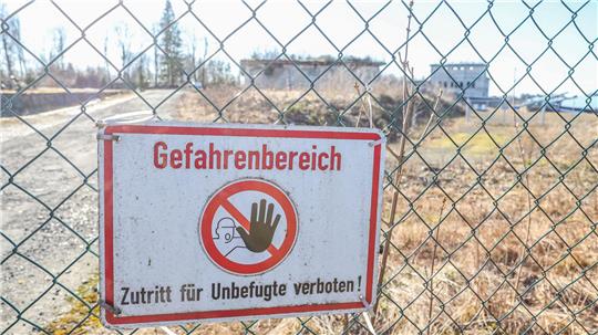 Das Foto zeigt im Hintergrund die alten Gebäude von Werk Tanne. Vorn hängt an einem Zaun das Schid "Gefahrenberich. Zutritt für Unbefugte verboten!"