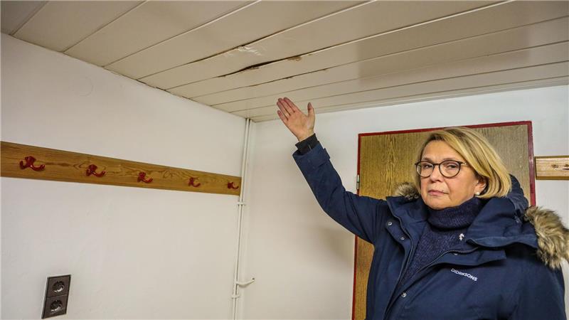 Vorsitzende Petra Hubert zeigt auf eine kaputte Decke