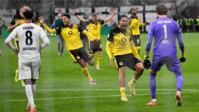 Elfmeterkrimi: BVB besiegelt frühes Pokal-Aus für Frankfurt Die Dortmunder Spieler stürmen auf Elfmeter-Held Kobel zu.