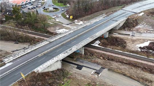 Luftbild einer gesperrten Brücke, die über zwei Straßen und eine Bahnlinie führt.