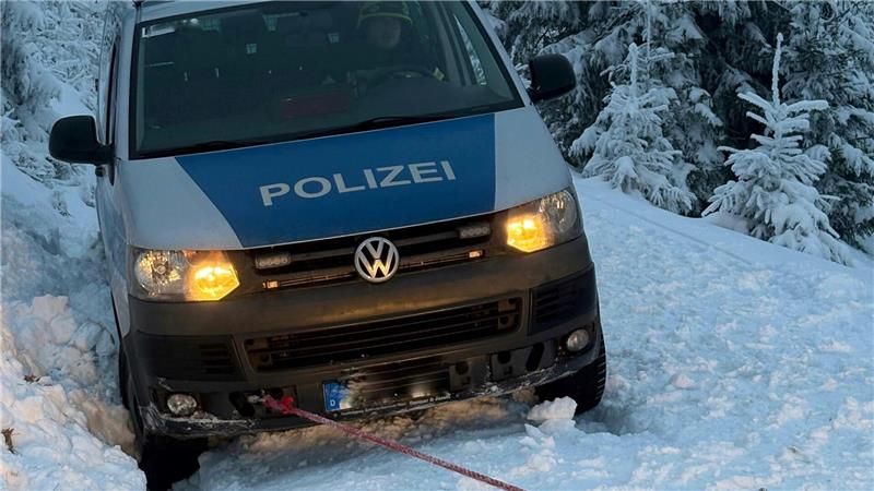 Das Foto zeigt ein Polizeifahrzeug, das im Schnee feststeckt.