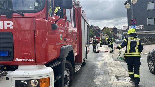 Die Einsatzkräfte der Feuerwehr Braunlage streuen die Ölspur ab, um später die Schadstoffe aufnehmen zu können und werden dabei von Autofahrern gefährdet.