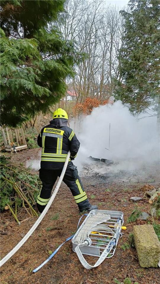 Die Einsatzkräfte der Freiwilligen Feuerwehr Hohegeiß löschen das Feuer im Garten eines Hohegeißers, in dem Bauholz verbrannt worden ist. Foto: Feuerwehr