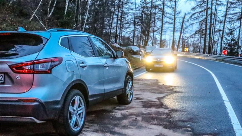 Ein silberner Nisan steht am Straßenrand und unter dem Wagen ist ein Pulver verstreut.